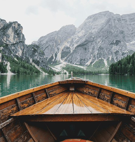 Beautiful mountain lake with towering cliffs and lush forests, captured from a wooden boat. Perfect.