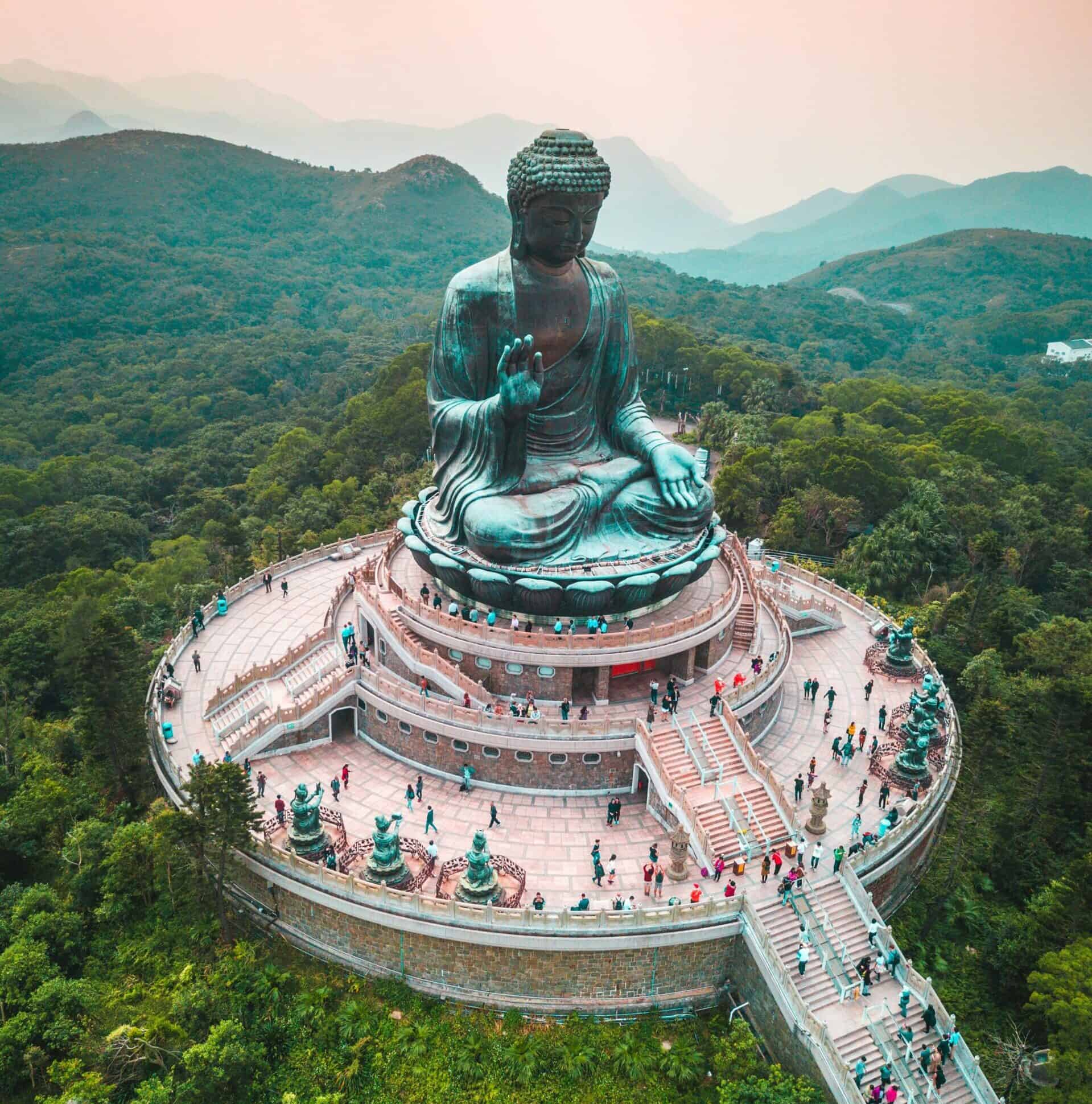 Buddha statue overlooking lush green mountains, symbolizing peace and spirituality in a scenic natur.